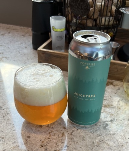 Portage New England DIPA in a pint can which is aquamarine in color. The beer is golden