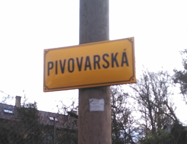 A yellow streetname signpost saying "Brewery (street)", Pivovarská in Czech.