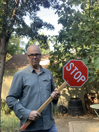 Pedestrian holding a stop sign on a stick used to deter drivers from running them over. 