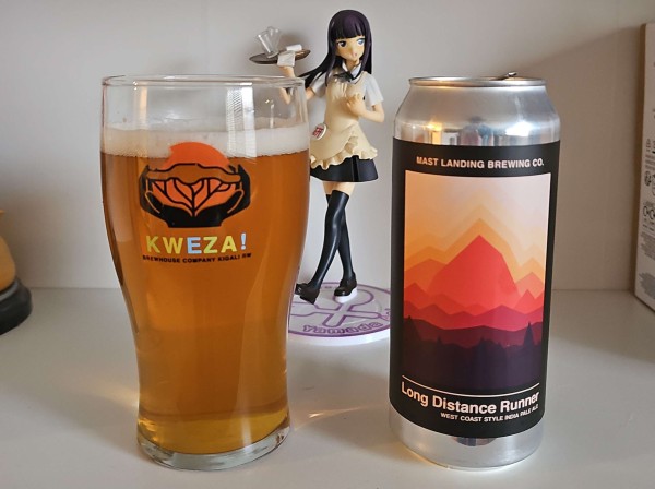 A glass filled with beer and a 16oz can sit on a shelf. Behind is an anime figure of Aoi Yamada from Working!!